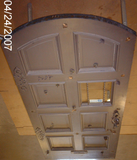 Photo of entrance door prior to wood and metal restoration.